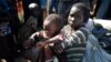 A newly-arrived displaced woman holds a child as they sit in the U.N. base in Bentiu, South Sudan, June 29, 2015. 