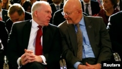 FILE - Then CIA Director John Brennan (L) speaks to then Director of National Intelligence James Clapper at the Justice Department in Washington, Jan. 17, 2014. Both Brennan and Trump had harsh words Friday for President Donald Trump at the Aspen Security Forum in Colorado.