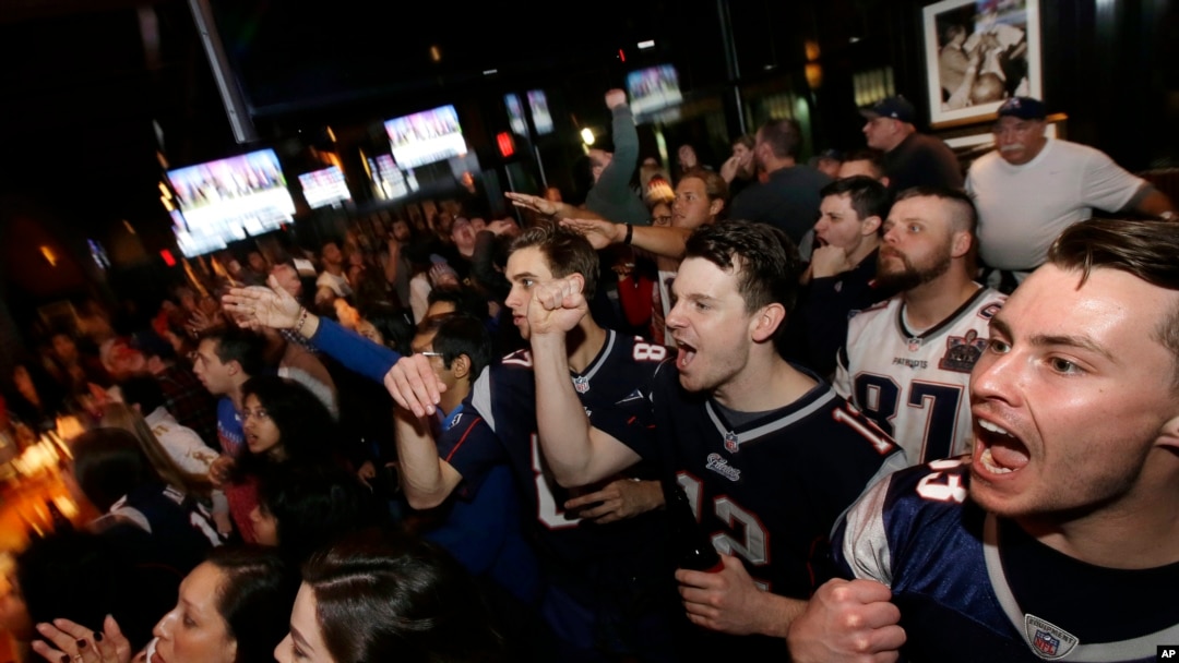 Coleman Hands, center, of Dallas, Davis Smith, second from right, of Austin, Texas, and Brian Moran, right, of Boston cheer while watching the first half of the NFL Super Bowl 52 football game between the New England Patriots and the Philadelphia Eagles in Minneapolis, Sunday, Feb. 4, 2018.