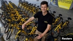 Ofo France general manager Laurent Kennel poses with city bike-sharing service Ofo bicycles at Autonomy and the Urban mobility summit in Paris, France, Oct. 19, 2017. 