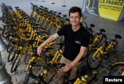 FILE - Ofo France general manager Laurent Kennel poses with city bike-sharing service Ofo bicycles at Autonomy and the Urban mobility summit in Paris, France, Oct. 19, 2017.