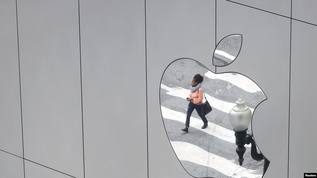 (资料照）2017年8月21日，一女子身影反射在美国加利福尼亚州旧金山市一苹果专卖店的标志中(photo:VOA)