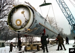 FILE - Soldiers prepare to destroy a ballistic SS-19 missile in the yard of the largest former Soviet military rocket base in Vakulenchuk, Ukraine, Dec. 24, 1997.