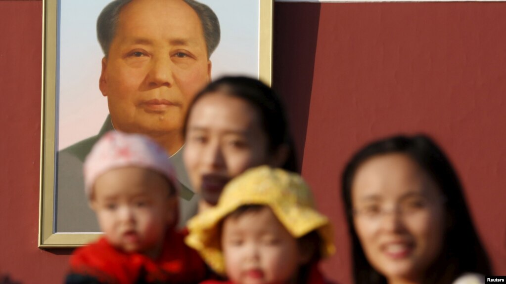资料照：两名中国妇女抱着她们的孩子在北京天安门毛泽东画像前留影。（2015年11月2日）(photo:VOA)