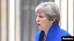 FILE - Britain's Prime Minister Theresa May makes a statement in Downing Street after traveling to Buckingham Palace to ask the Queen's permission to form a minority government, in London, June 9, 2017. 