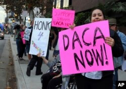 FILE - Demonstrators urging the Democratic Party to protect the Deferred Action for Childhood Arrivals program rally outside the office of California Democratic Sen. Dianne Feinstein in Los Angeles, Jan. 3, 2018.