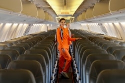 Flight attendants of SkyUp Airlines pose for a picture onboard a plane during the presentation of a new uniform at the Boryspil International Airport outside Kyiv, Ukraine September 30, 2021. (REUTERS/Gleb Garanich)