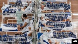 Pacijenti sa Kovidom 19 leže na krevetima u poljskoj bolnici sagrađenoj unutar jedne fiskulturne sale u Santo Andreu, u predgrađu Sao Paula u Brazilu, 9. juna 2020.