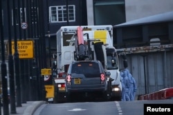 FILE - Forensics investigators work as a white van is carried away from London Bridge, after attackers rammed a hired van into pedestrians on London Bridge and stabbed others nearby killing and injuring people, in London, Britain, June 4, 2017.