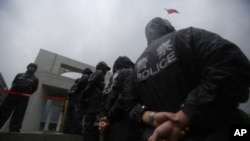 FILE - Police officers stand guard at the Hefei City Intermediate People's Court.