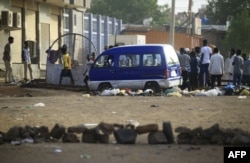 FILE - Protesters block a side street leading to their neighborhood in the Sudanese capital Khartoum to stop military vehicles from driving through the area on June 4, 2019.