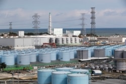 FILE - Nuclear reactors of No. 5, center left, and 6 look over tanks storing water that was treated but still radioactive, at the Fukushima Daiichi nuclear power plant in Okuma town, Fukushima prefecture, northeastern Japan, Feb. 27, 2021.