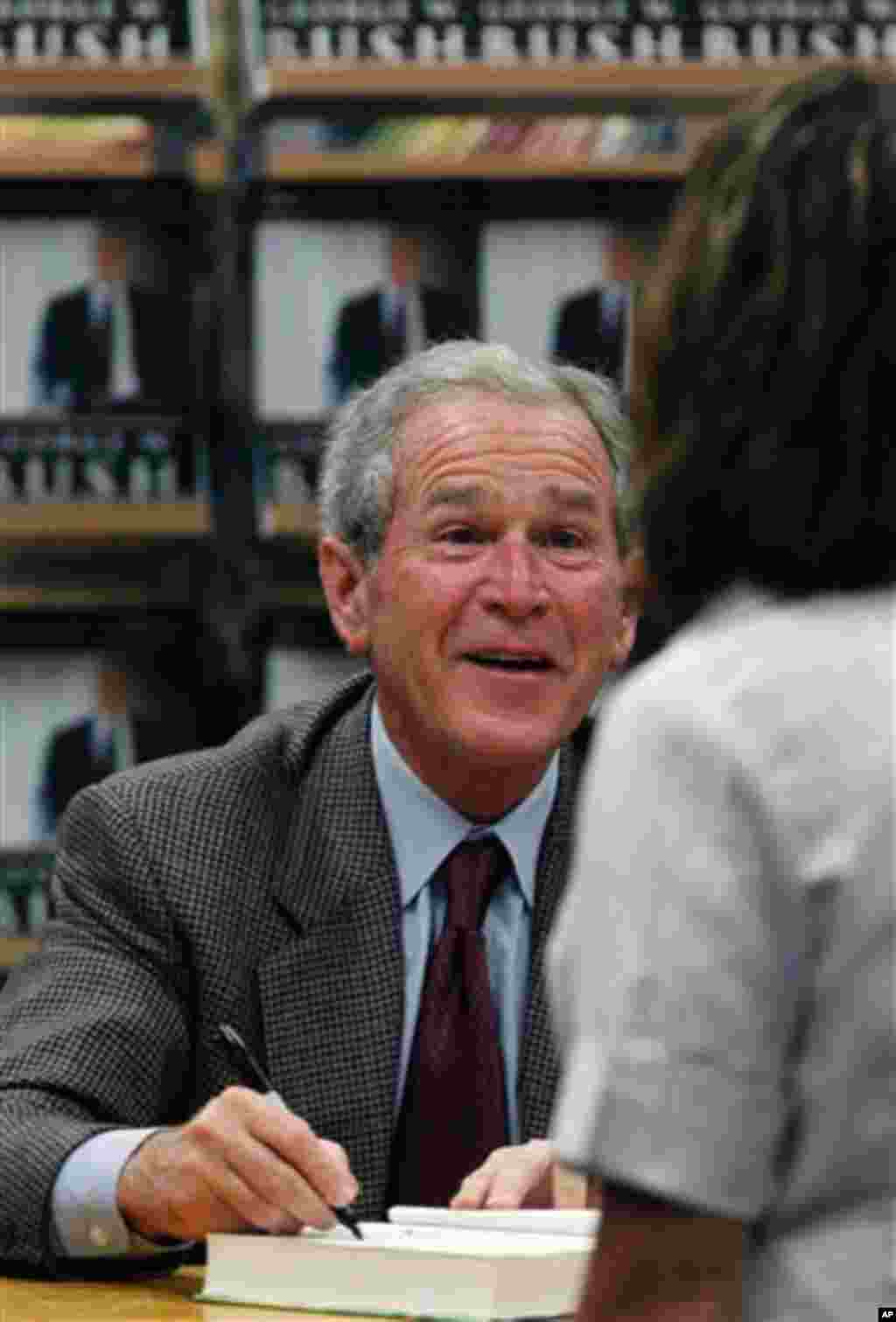 Former President George W. Bush signs a copy of his book "Decision Points" at a store near his Dallas home, Tuesday, Nov. 9, 2010. (AP Photo/LM Otero)