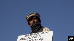 A Pakistani tribesman from North Waziristan tribal region holds a placard during a protest against U.S. drone strikes near the parliament house in Islamabad on 10, Dec 2010.