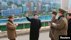 ​មេដឹកនាំ​កូរ៉េ​ខាង​ជើង​ Kim Jong Un (កណ្តាល) ធ្វើ​ទស្សនកិច្ច​ការដ្ឋាន​សាង​សង់​វិថី​ Mirae Scientists Street នៅ​ទីក្រុង​ព្យុងយ៉ាង​ (រូបថត​ទីភ្នាក់ងារ​ព័ត៌មាន​កូរ៉េ​ខាង​ជើង​ ផ្សាយ​កាលពី​ថ្ងៃទី​១៥ ខែ​កុម្ភៈ​ ឆ្នាំ​២០១៥)។ 