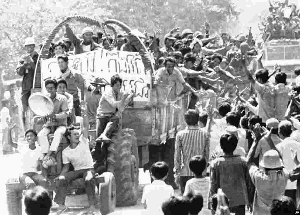 Unidentified persons wave to each other in Poipet, on the Cambodian-Thailand border, April 18, 1975, following the announcement of the fall of Phnom Penh to Khmer Rouge forces. A Khmer Rouge radio station announced that most of the top leaders of the former Phnom Penh government had been beheaded. The radio broadcast, monitored in Bangkok, also indicated fighting is still continuing in Cambodia&#39;s provinces. (AP Photo)