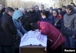 Relatives mourn next to a coffin of Alexei Alexeev, a victim of a Russian airliner which crashed in Egypt, during a funeral ceremony at the Bogoslovskoye cemetery in St. Petersburg, Russia, Nov. 5, 2015.