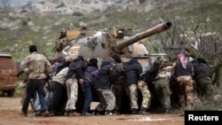 FILE - Fighters from the Suqour al-Sham Brigade, which is part of the Free Syrian Army, take cover from snipers during what activists said were clashes with forces of Syria's President Bashar al-Assad, in the al-Arbaeen mountain area of western Idlib, Jan. 30, 2015.