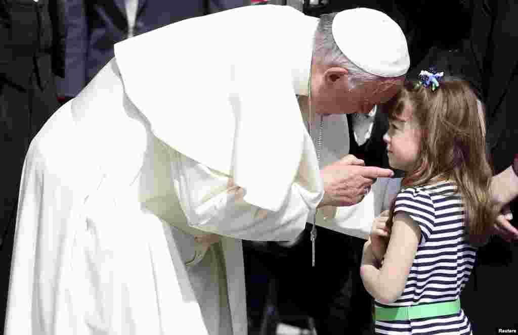 로마 교황청 성베드로 광장에서 열린 주간 알현 행사에서 프란치스코 교황이 미국 오하이오주 출신 5살 소녀 엘리자베스 리지 마이어스와 대화하고 있다. 엘리자베스는 시각과 청각 장애를 일으키는 유전병인 &#39;어셔 증후군&#39;을 앓고 있다.