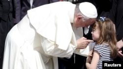 FILE - Pope Francis talks with Elizabeth 'Lizzy' Myers, a 5-year-old girl from Ohio, U.S. who suffers from a genetic disease known as Usher syndrome, which leads to blindness and hearing loss at the end of the weekly audience in Saint Peter's Square at the Vatican April 6, 2016.