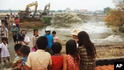 Children sit on top their inundated homes, where Shukaku, Inc., has been pumping fill into Boeung Kak lake, (File photo).