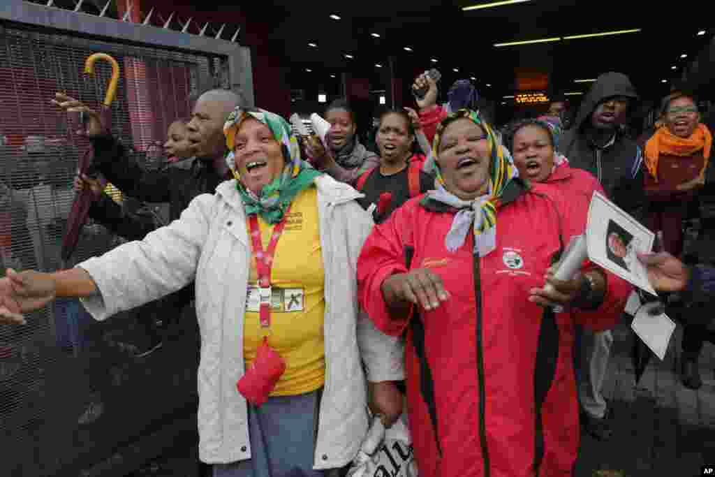 As pessoas dançam e cantam enquanto entram para o Estádio para participar na cerimónia fúnebre em honra a&nbsp; Nelson Mandela, no Soweto, junto a Joanesburgo, Dez. 10, 2013.