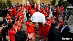 FILE - Members of Lebanese Red Cross carry a coffin of Hanna Lahoud, who was killed in Taiz in southwestern Yemen by unknown gunmen who opened fire on the International Red Cross car, during a mass funeral in Zouk Mosbeh, Lebanon, April 28, 2018.