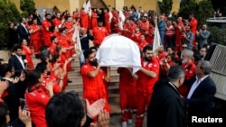 FILE - Members of Lebanese Red Cross carry a coffin of Hanna Lahoud, who was killed in Taiz in southwestern Yemen by unknown gunmen who opened fire on the International Red Cross car, during a mass funeral in Zouk Mosbeh, Lebanon, April 28, 2018.