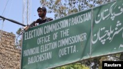 FILE - A policeman stands guard at an election commission office in Quetta, May 8, 2013. Pakistan's Election Commission has again rejected the registration of Milli Muslim League, citing its alleged terror ties. General elections are scheduled for July 25.