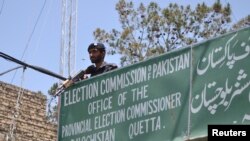 FILE - A policeman stands guard at an Election Commission office in Quetta, Pakistan, May 8, 2013. The Election Commission has twice rejected the registration of Milli Muslim League, citing its alleged terror ties. General elections are scheduled for July 25.