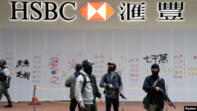 携带枪支的香港便衣警察守卫着汇丰银行在香港元旦大游行期间遭到遭到破坏的湾仔分行。（2020年1月1日）