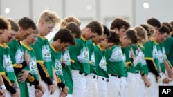 Santa Fe High School baseball players bow their heads in a moment of silence for the shooting victims at their school before a baseball game against Kingwood Park High School in Deer Park, Texas, May 19, 2018.