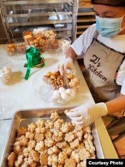 Agnes Zigmund mempersiapkan kue-kuenya ke dalam wadah. (Foto courtesy)