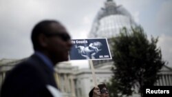 FILE - A woman holds a sign showing a baby as she attends a "Women Betrayed Rally to Defund Planned Parenthood" at Capitol Hill in Washington, July 28, 2015. 