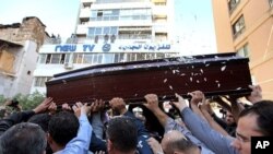 Mourners carry the coffin of Lebanese television cameraman Ali Shaaban, of Al-Jadeed TV who was shot dead on the Lebanon-Syria border, in front of Al-Jadeed TV, in Beirut, Lebanon, April 10, 2012. 