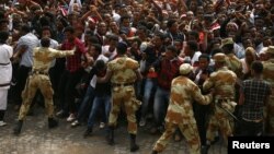 FILE - Demonstrators chant slogans while flashing the Oromo protest gesture during Irreecha, the thanksgiving festival of the Oromo people, in Bishoftu town, Oromia region, Ethiopia, Oct. 2, 2016.