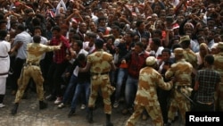 FILE - Demonstrators chant slogans while flashing the Oromo protest gesture during Irreecha, the thanksgiving festival of the Oromo people, in Bishoftu town, Oromia region, Ethiopia, Oct. 2, 2016. Government says on Wednesday it is releasing nearly 10,000 people detained under its ongoing state of emergency. 