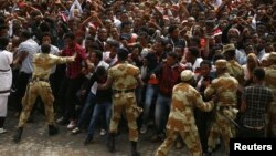 FILE - Demonstrators chant slogans while flashing the Oromo protest gesture during Irreecha, the thanksgiving festival of the Oromo people, in Bishoftu town, Oromia region, Ethiopia, Oct. 2, 2016. Government says on Wednesday it is releasing nearly 10,000 people detained under its ongoing state of emergency.