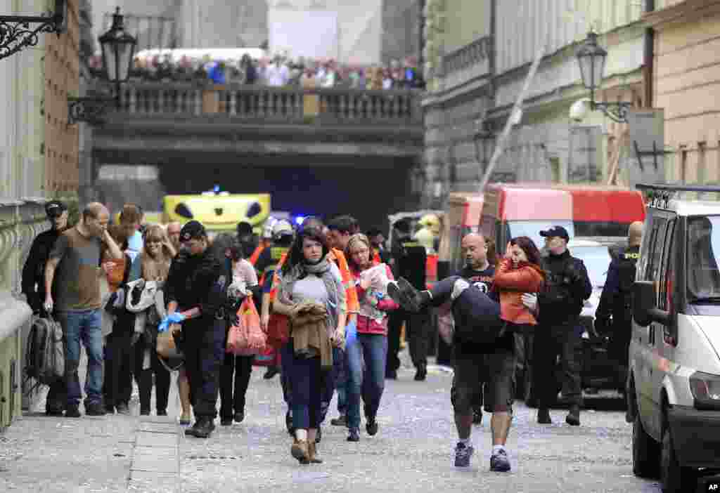 Injured people leave the scene of an explosion in Prague, Czech Republic, April 29, 2013.