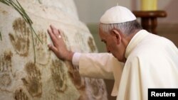 Pope Francis prays in front of the Virgin Mary statue at Caacupe church in Caacupe, outside of Asuncion, Paraguay, July 11, 2015. 