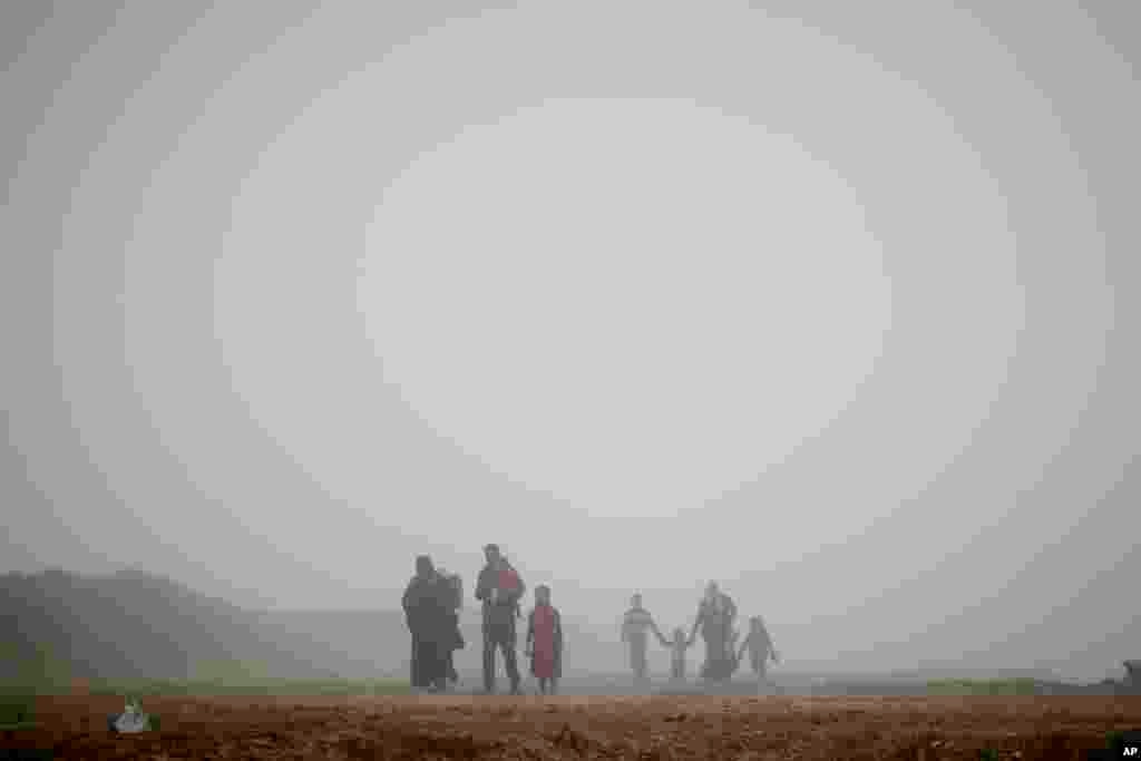 Displaced people walk through heavy fog during fighting between Iraqi security forces and Islamic State militants in west Mosul, Iraq.