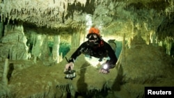 FILE - A scuba diver measures the length of Sac Aktun underwater cave system as part of the Gran Acuifero Maya Project near Tulum, in Quintana Roo state, Mexico, Jan. 24, 2014. Herbert Mayrl/Courtesy Gran Acuifero Maya Project (GAM) handout.