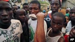 A man shows on his arm where he was injured at a rally in support of UFDG presidential candidate Cellou Dalein Diallo in Conakry, Guinea, Oct. 8, 2015.