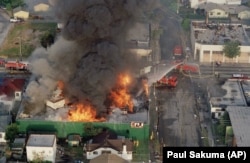In this April 30, 1992 file photo, a fire burns out of control at the corner of 67th Street and West Boulevard in South Central Los Angeles. On April 29, 1992, four white police officers were declared innocent in the beating of black motorist.