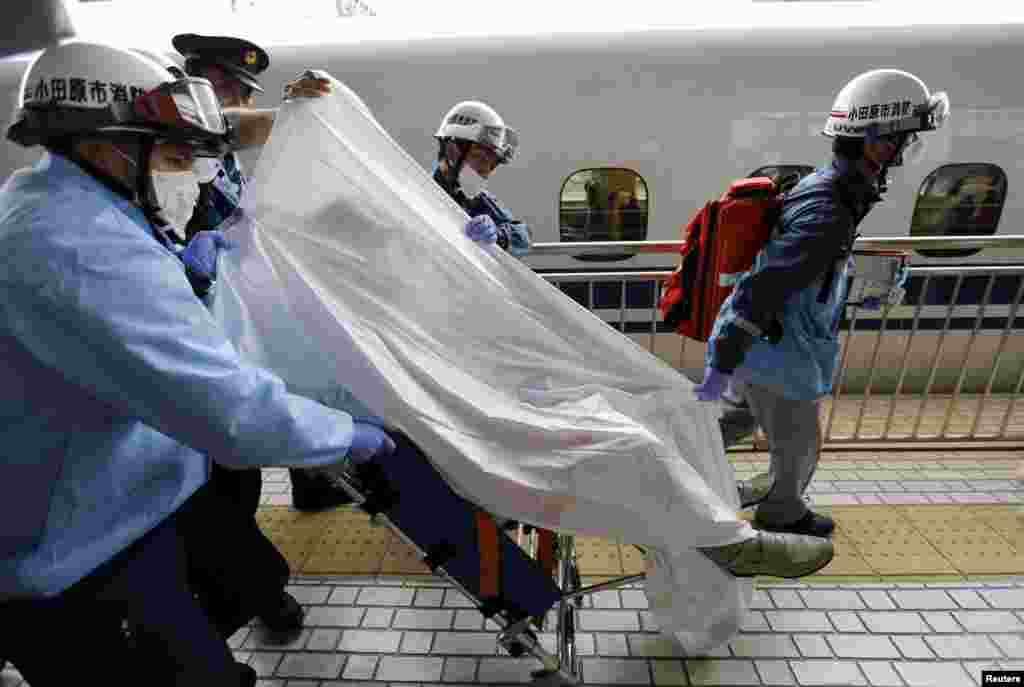 A passenger on a stretcher is carried by ambulance officers at Odawara station after it made an emergency stop, in Odawara, west of Tokyo. Two passengers on a Japanese Shinkansen bullet train died after one doused himself in oil and set himself ablaze, media reports said. The train, carrying about 1,000 passengers, made an emergency stop on its way from Tokyo to the western city of Osaka after smoke started to fill at least one carriage, fire department officials said. A fire department official confirmed that one man was dead.