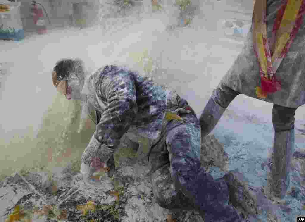 Revelers, dressed in mock military uniforms, take part in the battle of &quot;Enfarinats&quot;, a flour fight, in the town of Ibi, south-eastern Spain.