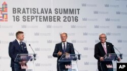 European Council President Donald Tusk, center, participates in a media conference with European Commission President Jean-Claude Juncker, right, and Slovakian Prime Minister Robert Fico at the conclusion of an EU summit in Bratislava, Sept. 16, 2016.