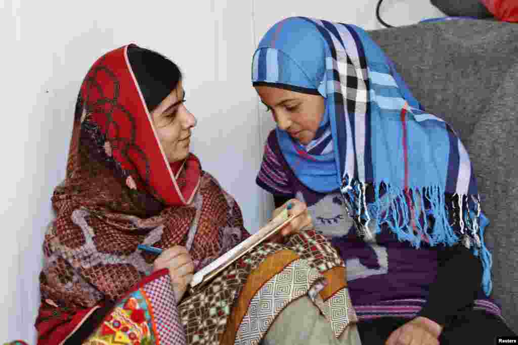 Pemenang Hadiah Nobel Perdamaian Malala Yousafzai (kiri) berbicara dengan pengungsi Suriah Mazoon Rakan, 16, mengenai pengalaman Mazoon, dalam kunjungan ke kamp pengungsi Zaatri, kota Mafraq, di Yordania, Februari 2014.&nbsp;(Reuters/Muhammad Hamed) 