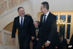 U.S. Secretary of State, Mike Pompeo, left, and Hungary's Minister for Foreign Affairs and Trade, Peter Szijjarto, chat during talks in Budapest, Hungary, Feb. 11, 2019.