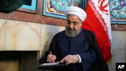 Hasan Rohani popunjava listić tokom jučerašnjeg glasanju, na izbornom mestu u Teheranu 